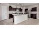 Modern kitchen featuring dark cabinets, granite countertops, and a functional center island at 30938 W Mitchell Dr, Buckeye, AZ 85396