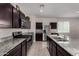 Well-equipped kitchen with granite counters, dark wood cabinets and stainless steel appliances at 30938 W Mitchell Dr, Buckeye, AZ 85396