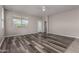 Bright living room boasts stylish wood-look floors, a ceiling fan, and natural light at 30938 W Mitchell Dr, Buckeye, AZ 85396