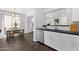Modern kitchen with white cabinets, black countertop and subway tile backsplash, open to dining and living area at 3131 S Mingus Dr, Chandler, AZ 85286
