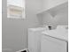 Bright laundry room with white washer and dryer, overhead shelf, and a window at 3131 S Mingus Dr, Chandler, AZ 85286