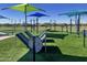 Outdoor fitness park with multiple exercise stations, green artificial turf, and shaded areas at 3131 S Mingus Dr, Chandler, AZ 85286