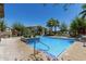 Community pool with blue tile, shallow end step, tropical plants, lounge chairs, and umbrellas at 3131 S Mingus Dr, Chandler, AZ 85286
