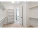 Open walk-in closet featuring built-in shelving and access to the bathroom at 31652 N Misty Ln, Queen Creek, AZ 85142