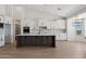 Modern kitchen featuring sleek white cabinets, contrasting island, and plenty of natural light from a large window at 31652 N Misty Ln, Queen Creek, AZ 85142