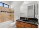 Charming bathroom with tiled shower/tub, vanity with black countertop, and modern fixtures, creating a comfortable space at 3215 E Constance Way, Phoenix, AZ 85042