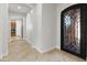 Hallway with tile flooring leads to the kitchen and a decorative black wrought-iron door at 3215 E Constance Way, Phoenix, AZ 85042