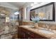 Bathroom with dual sinks, granite counters, and glass enclosed shower at 3911 W Quail Ave, Glendale, AZ 85308