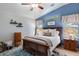 Comfortable bedroom featuring a wood bed frame, soft rug and decorative blue accent wall at 3911 W Quail Ave, Glendale, AZ 85308