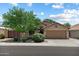 Charming home exterior with mature tree, two car garage and neutral color palette at 3911 W Quail Ave, Glendale, AZ 85308
