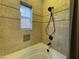 A clean, tiled bathtub with a shower head and window provides relaxation at 3935 E Rough Rider Rd # 1066, Phoenix, AZ 85050