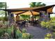 Charming outdoor dining area with shade, stone pillars, and desert landscaping, ideal for gatherings at 3935 E Rough Rider Rd # 1066, Phoenix, AZ 85050