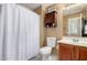 Cozy bathroom featuring a wood cabinet, white toilet, sink, and a cabinet for convenient storage at 4072 E Windsor Dr, Gilbert, AZ 85296
