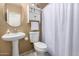 Cozy bathroom featuring a white toilet, pedestal sink, and a cabinet for convenient storage at 4072 E Windsor Dr, Gilbert, AZ 85296