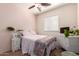 Bright bedroom with a ceiling fan, large window, and cozy bed with decorative pillows and comforter at 4072 E Windsor Dr, Gilbert, AZ 85296
