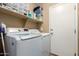 Bright laundry room featuring modern washer and dryer units, plus shelving for storage at 4072 E Windsor Dr, Gilbert, AZ 85296