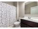 Bathroom featuring a vanity, white sink, cherry cabinet, toilet, and a shower with patterned curtain at 42098 W Balsa Dr, Maricopa, AZ 85138