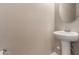 Pedestal sink, decorative mirror and neutral wall textures enhance this powder room at 42098 W Balsa Dr, Maricopa, AZ 85138