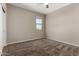 Comfortable bedroom with neutral walls, plush carpeting, and a window providing natural light and an airy atmosphere at 42098 W Balsa Dr, Maricopa, AZ 85138