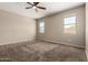 A bright and open bedroom with plush carpet flooring and a ceiling fan at 42098 W Balsa Dr, Maricopa, AZ 85138