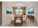 Bright dining room features modern chandelier, neutral walls and large windows at 42098 W Balsa Dr, Maricopa, AZ 85138