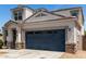 Picture of a two-car garage with an attached two-story house. Desert landscaping and a walkway are visible at 42098 W Balsa Dr, Maricopa, AZ 85138