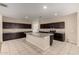 Spacious kitchen boasts dark cabinets, granite countertops and large center island at 42098 W Balsa Dr, Maricopa, AZ 85138