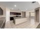 The kitchen has dark cabinets, stainless appliances, granite countertops and a center island at 42098 W Balsa Dr, Maricopa, AZ 85138