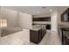 Open kitchen with granite island, dark cabinets and seamless transition to living area at 42098 W Balsa Dr, Maricopa, AZ 85138