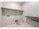 Functional laundry room features practical shelving, convenient hookups and tile flooring for easy maintenance at 42098 W Balsa Dr, Maricopa, AZ 85138