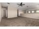 Open living area with plush carpeting, neutral walls, and a ceiling fan, creating a comfortable space at 42098 W Balsa Dr, Maricopa, AZ 85138