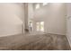 Spacious living room with high ceilings, plush carpeting, and staircase leading to the second floor at 42098 W Balsa Dr, Maricopa, AZ 85138