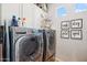 Well-equipped laundry room featuring modern washer and dryer units and overhead cabinets at 4215 E Ronald St, Gilbert, AZ 85295