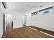 Sunny bedroom with wood floors, ceiling fan, and large windows with modern shades at 4312 E Roma Ave, Phoenix, AZ 85018