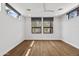 Bright bedroom features hardwood floors, recessed lighting, and two windows providing great natural light at 4312 E Roma Ave, Phoenix, AZ 85018