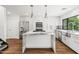 Bright, modern kitchen features stone island, stainless appliances, sink with a window, and contemporary fixtures at 4312 E Roma Ave, Phoenix, AZ 85018
