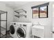 Modern laundry room with shelving, basin, and front loading machines at 4312 E Roma Ave, Phoenix, AZ 85018