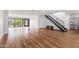 Bright living room with hardwood floors, staircase, and large sliding glass doors that open to a landscaped backyard at 4312 E Roma Ave, Phoenix, AZ 85018