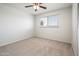 This bedroom features neutral carpeting, a ceiling fan, and a window for natural light at 4414 S Ventura Dr, Tempe, AZ 85282
