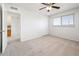 This bedroom features neutral carpeting, a ceiling fan, and a window for natural light at 4414 S Ventura Dr, Tempe, AZ 85282