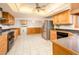 Bright kitchen featuring stainless steel appliances, wooden cabinets, and tile flooring at 4414 S Ventura Dr, Tempe, AZ 85282