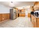 Spacious kitchen showcasing stainless steel appliances, wood cabinets, and a tile floor at 4414 S Ventura Dr, Tempe, AZ 85282