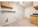 Spacious laundry room with tile flooring, cabinets, and ample space for appliances at 4414 S Ventura Dr, Tempe, AZ 85282
