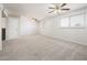This living room features neutral carpeting, ceiling fans, and a window for natural light at 4414 S Ventura Dr, Tempe, AZ 85282