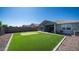 Wide backyard featuring a putting green, patio, rock, and a block wall at 44232 W Palo Cedro Rd, Maricopa, AZ 85138