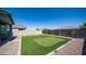 Spacious backyard featuring a putting green, patio, rock, and a tall block wall at 44232 W Palo Cedro Rd, Maricopa, AZ 85138