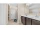 Bathroom featuring double sinks, dark cabinets, tile flooring, and a combined shower and toilet at 44232 W Palo Cedro Rd, Maricopa, AZ 85138