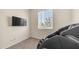 Minimalist bedroom with a mounted TV, large windows, and a massage chair at 44232 W Palo Cedro Rd, Maricopa, AZ 85138