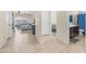Hallway leading to living area and bathroom with light-colored tile floors and neutral-toned walls at 44232 W Palo Cedro Rd, Maricopa, AZ 85138