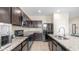 Kitchen with granite countertops, modern stainless steel appliances, and dark cabinets at 44232 W Palo Cedro Rd, Maricopa, AZ 85138